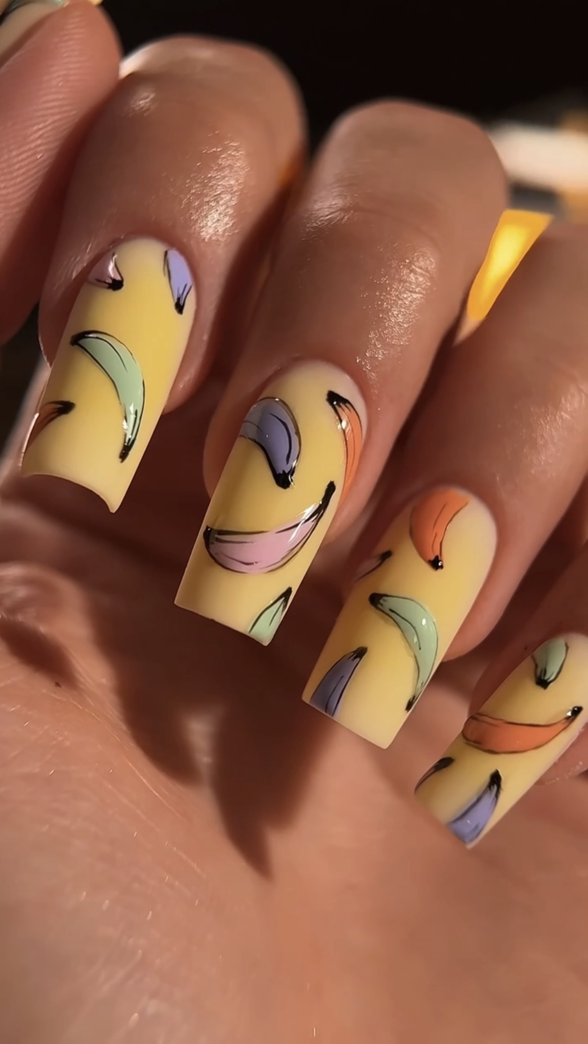 Lange gele nagels met bananen in verschillende kleuren
