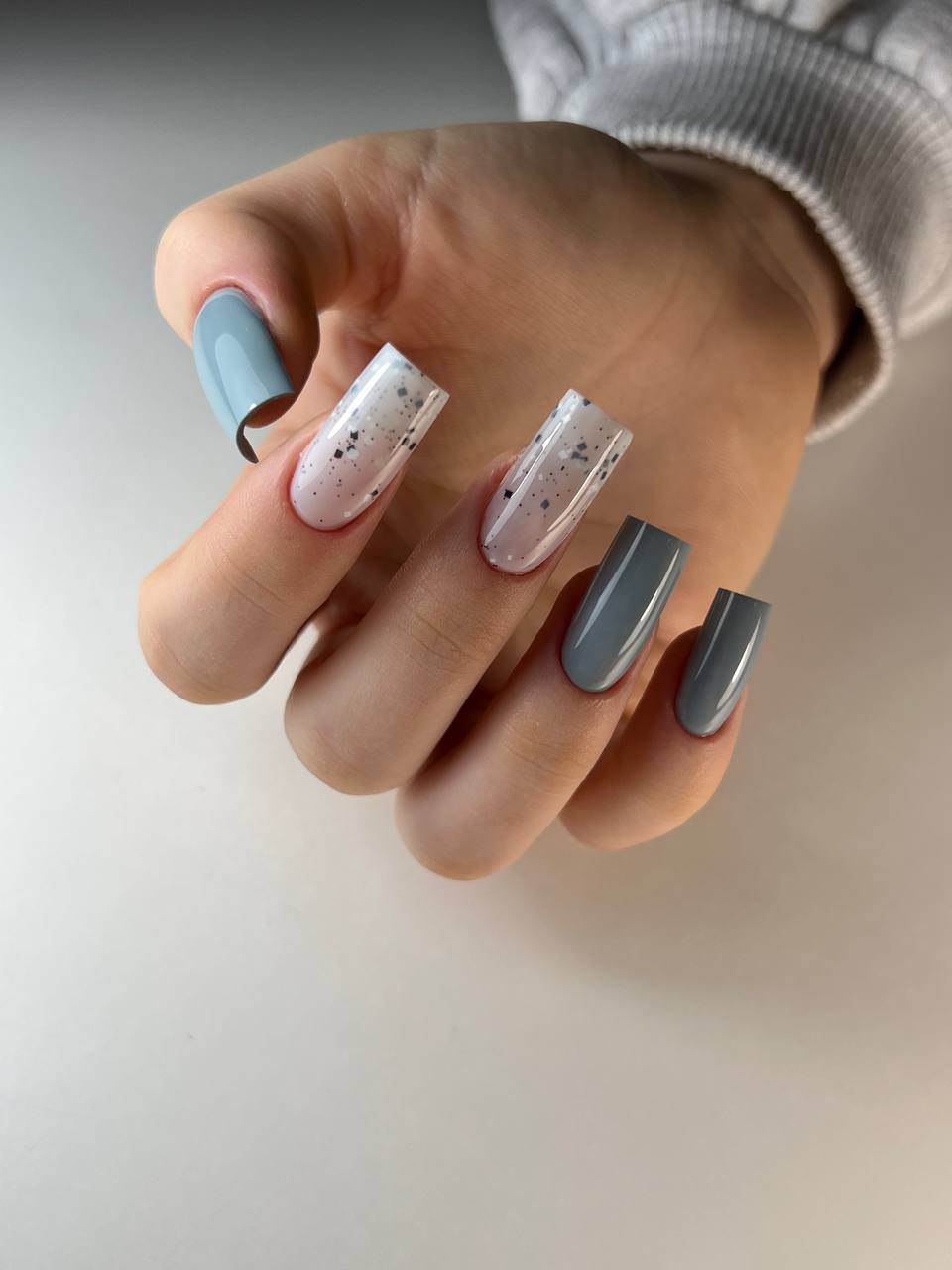 Nagels in lichtblauw, wit met spikkels en grijs