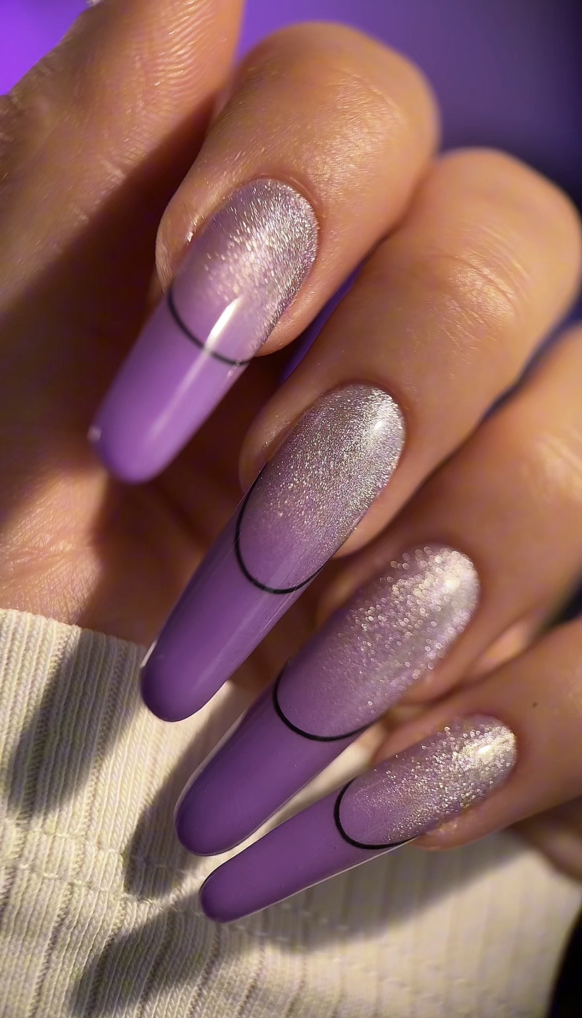 Lange paarse nagels met zilverglitter en zwarte lijntjes
